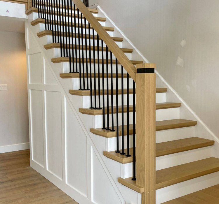 light colored wood and white staircase with wrought iron spindles