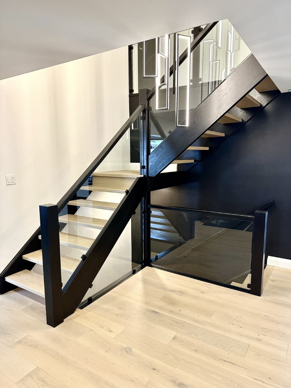 black and light wood corner staircase and glass panels