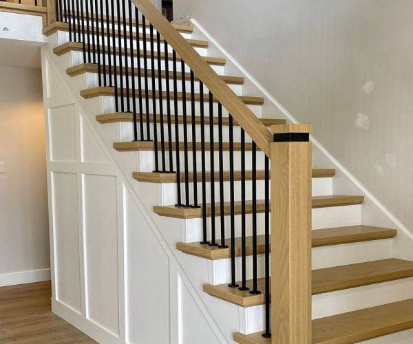 light colored wood and white staircase with wrought iron spindles