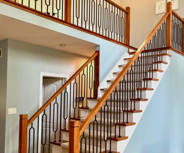 wooden staircase with wrought iron spindles